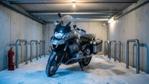 Moto stationnée et sécurisée dans un garage collectif pendant l’hiver, avec dispositifs de protection contre le vol et l’incendie.
